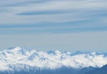 International Mountain Day: Celebrating the Majestic Heights and Their Importance view of a snow-covered mountain range with hikers at the peak