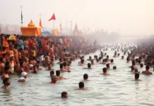 Kumbh Mela Last Date – Everything You Need to Know About This Sacred Event devotees taking a holy dip at Sangam during Kumbh Mela, with the serene river waters and spiritual processions in the background.